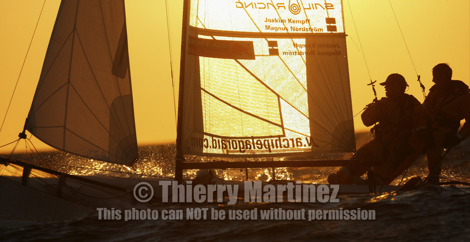 03_3250D © Th.Martinez,STOCKHOLM ARCHIPELAGO SWEDEN, 10 07 03-Archipelago Raid (2003)  Day 3..Team NOKIA-Kempff  Magnus Nordstrom (SWE)& Joakim Kempff (SWE) sailing in sunset light on the way back from Finland to Sweden.