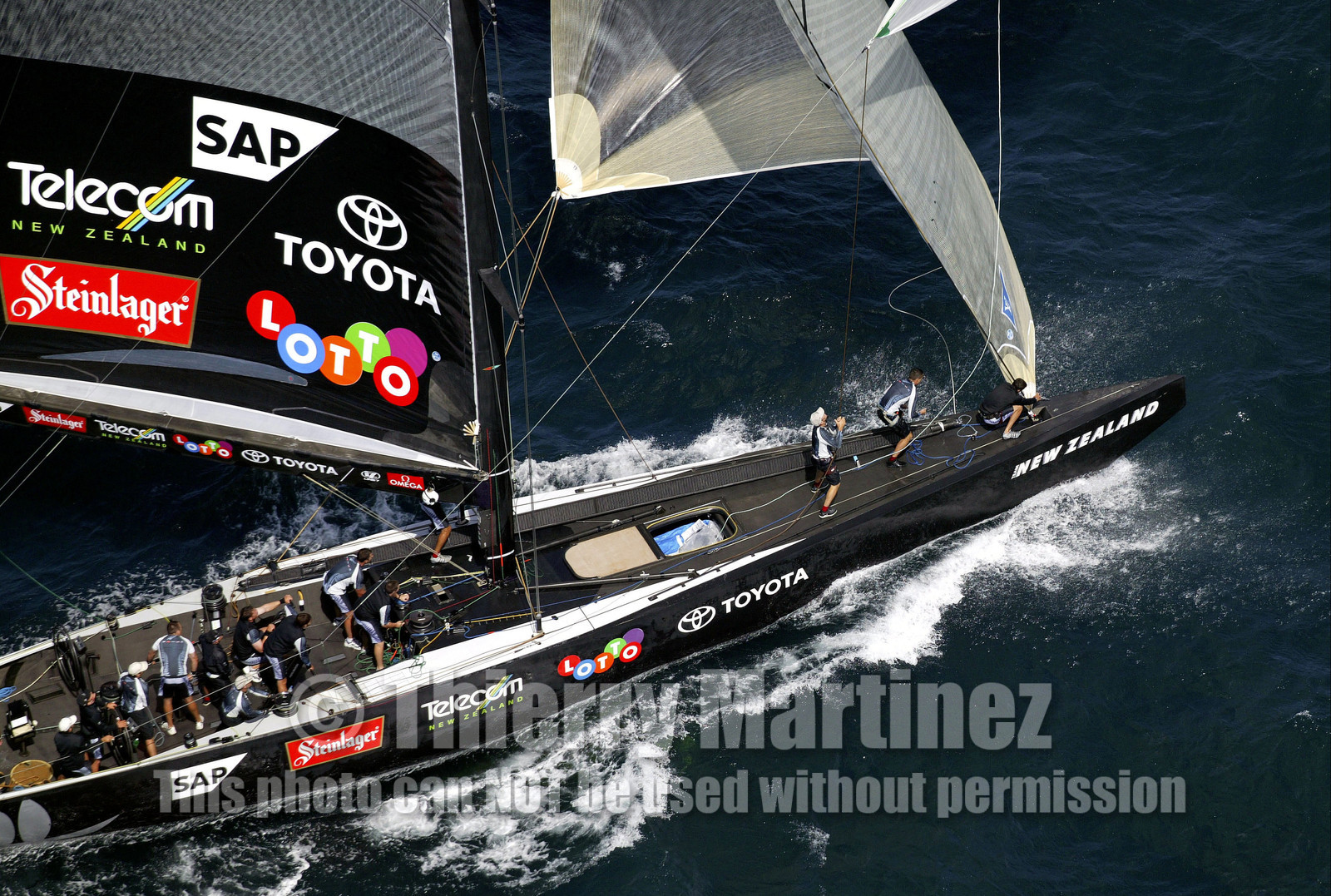 03_0194D ©Th.Martinez - Auckland (NZ) . America's Cup 2003. 18th February 2003. Day 3..Alinghi (SUI 64) vs Team NZ (NZL 82) .Team NZ 's crew droping head sail after setting up spinnaker at upwind mark...