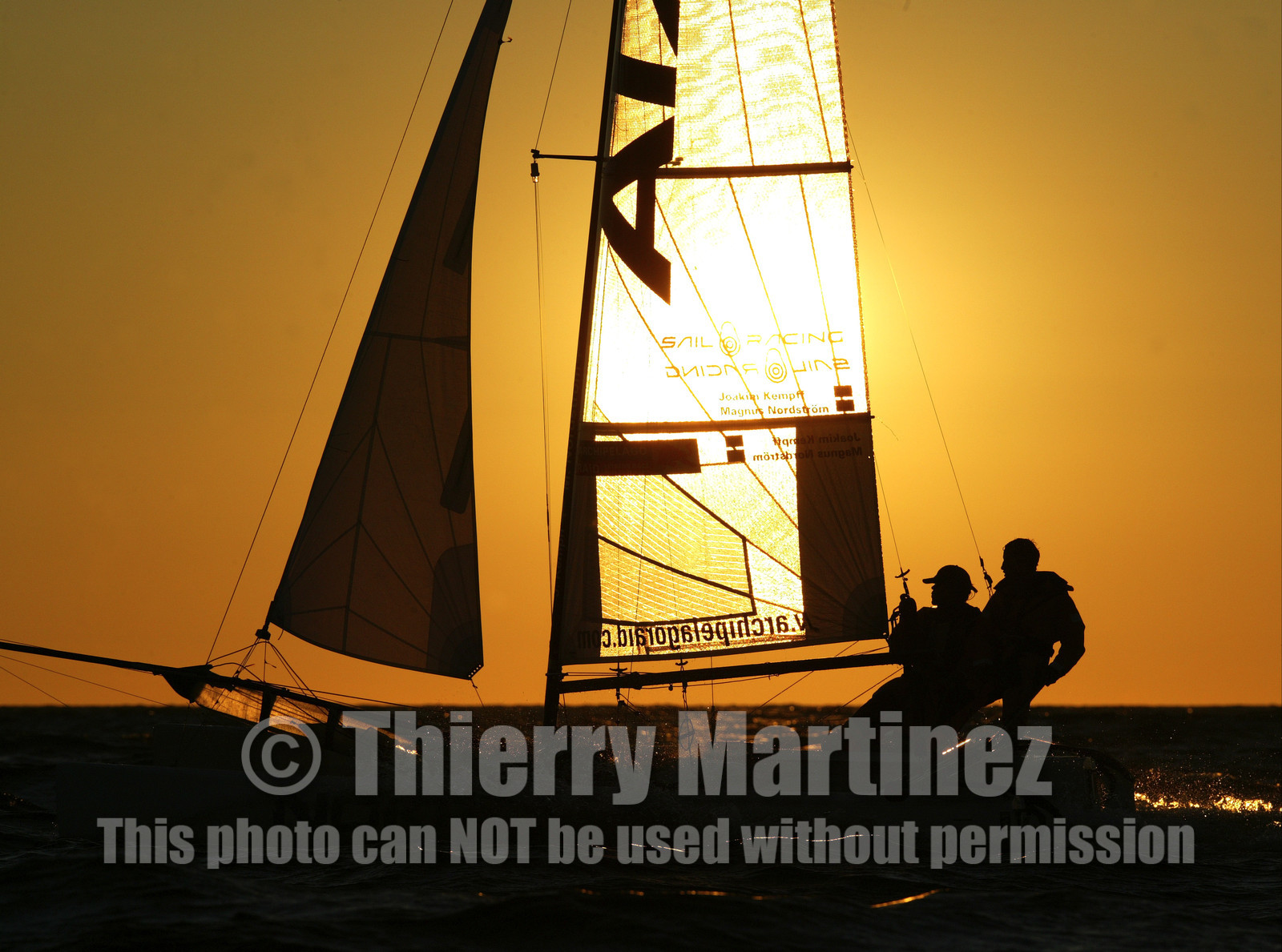 03_3246D  © Th.Martinez,STOCKHOLM ARCHIPELAGO SWEDEN, 10 07 03-Archipelago Raid (2003)  Day 3..Team NOKIA-Kempff  Magnus Nordstrom (SWE)& Joakim Kempff (SWE) sailing in sunset light on the way back from Finland to Sweden.